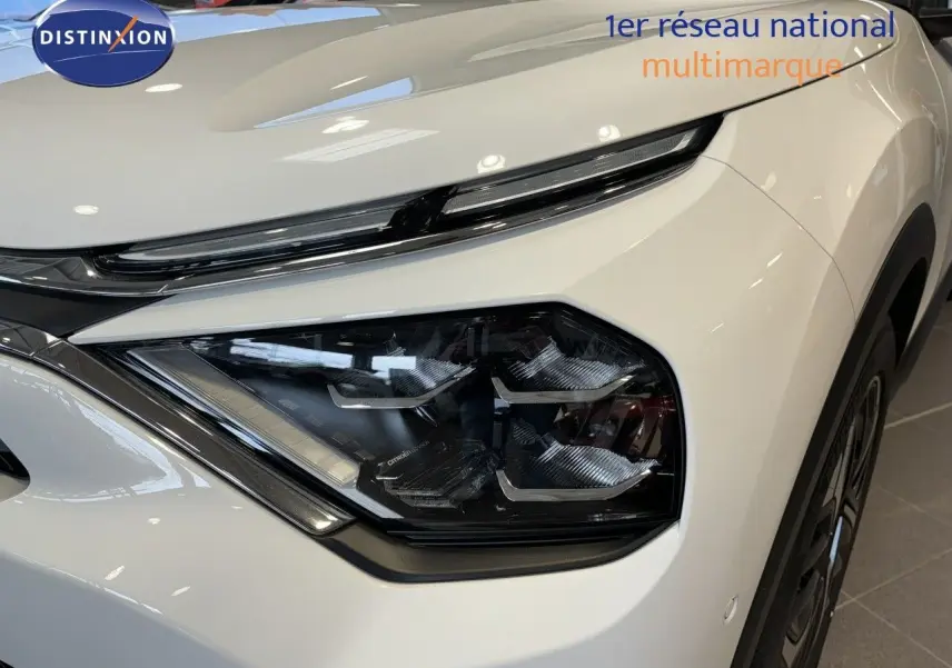 Gros plan sur le phare avant droit blanc du Citroën C4 2022, soulignant son design moderne et ses lignes épurées.