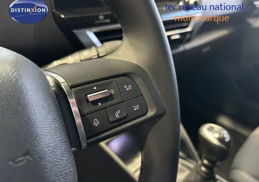 Gros plan sur la commande de volume au volant d'une Citroën C4 blanche essence 2022, boîte manuelle visible en arrière-plan.