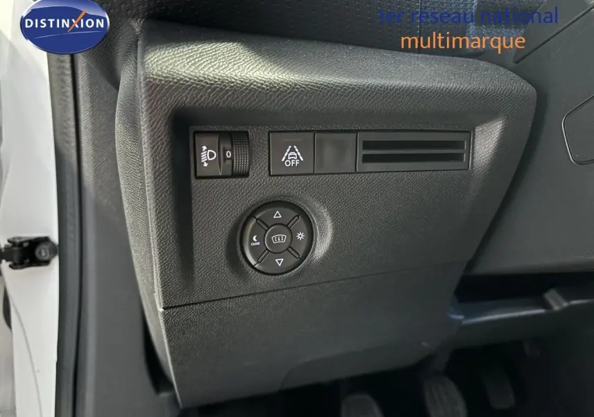 Gros plan sur les commandes de réglage des phares et aides à la conduite côté gauche d'une Citroën C4 blanche 2022.