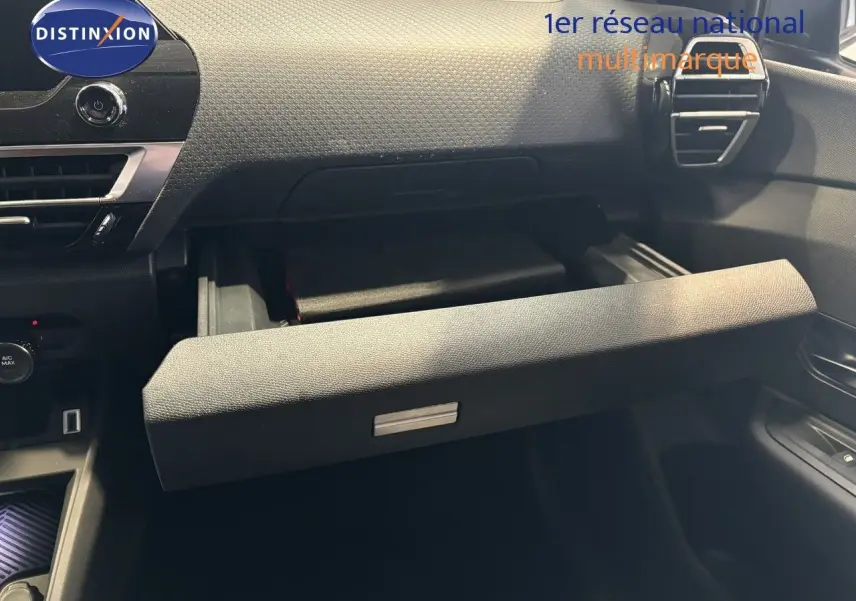 Intérieur de la Citroën C4 2022 blanc, vue sur la boîte à gants ouverte côté passager avec tableau de bord texturé.