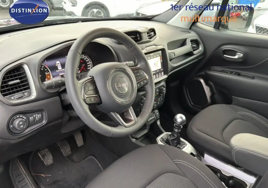 Intérieur noir du Jeep Renegade 2022, vue côté conducteur montrant volant, tableau de bord et levier de vitesse manuel.