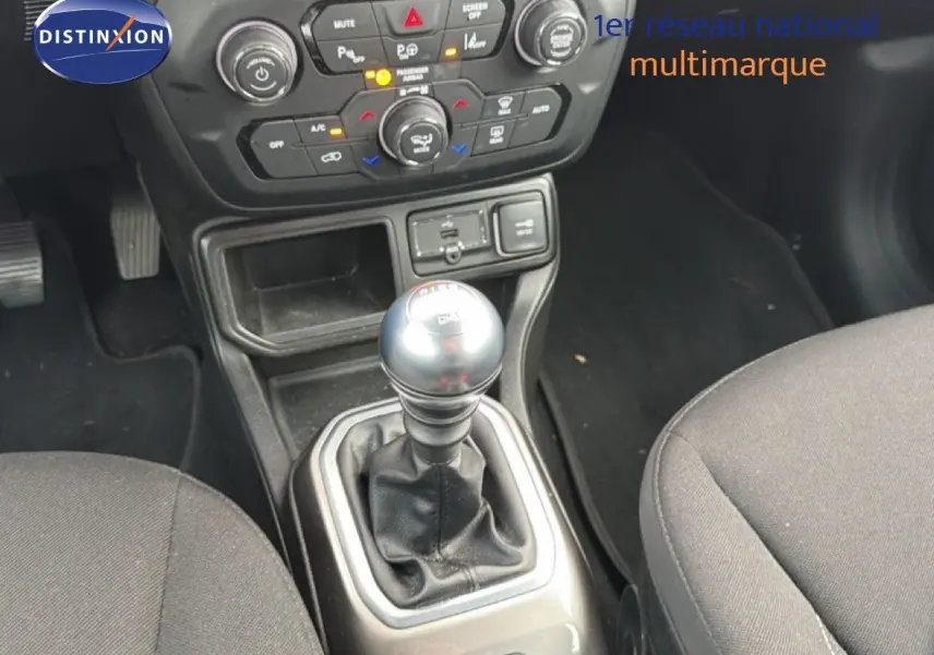 Le levier de vitesses manuel au centre de la console d'une Jeep Renegade noire, avec commandes de climatisation visibles.
