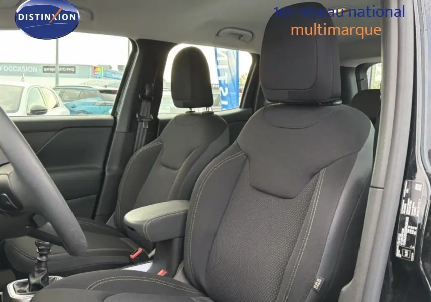 Vue intérieure côté conducteur du Jeep Renegade noir 2022, sièges tissus gris foncé avec accoudoir central.