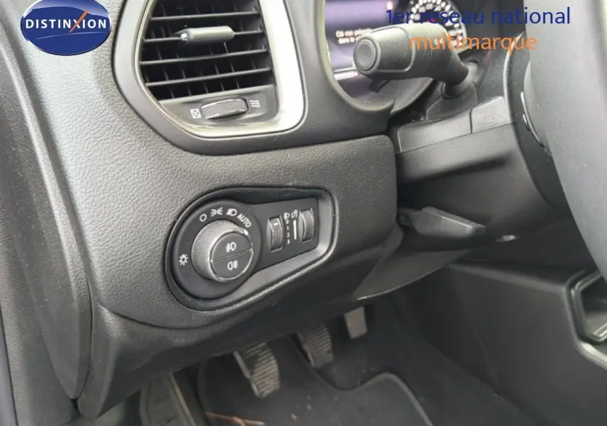 Détail du tableau de bord côté gauche du Jeep Renegade noir 2022, avec commandes d'éclairage et pédales visibles.