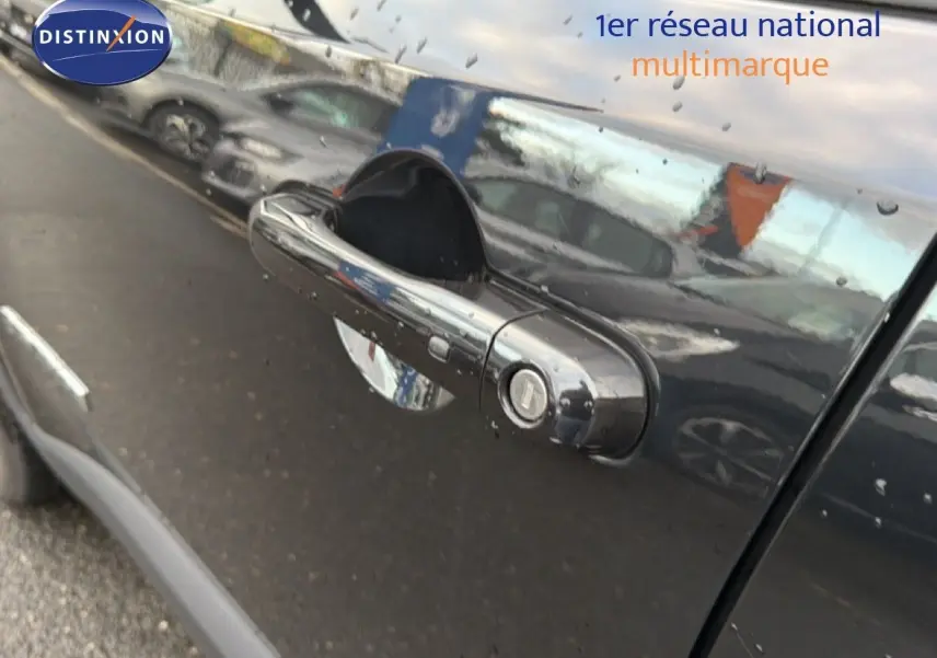 Poignée de porte noire brillante du côté gauche d'un Jeep Renegade 2022 Diesel avec reflets d'autres véhicules.