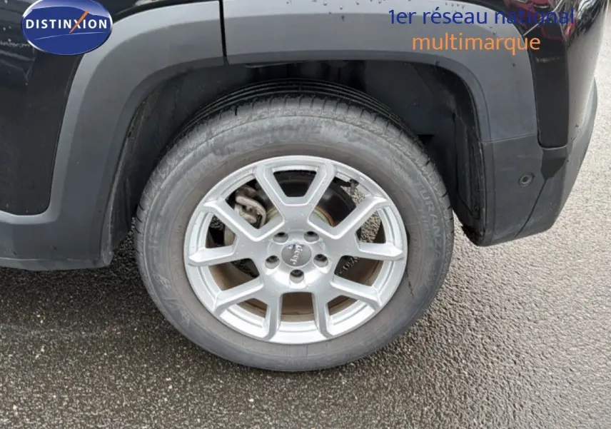 Gros plan sur la roue arrière gauche d'un Jeep Renegade noir 2022 avec jante alu argentée et logo Jeep au centre.