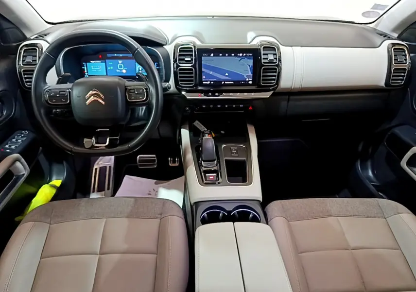Intérieur du Citroën C5 Aircross Hybrid 225 vue de face, tableau de bord clair avec écran tactile et volant cuir noir.