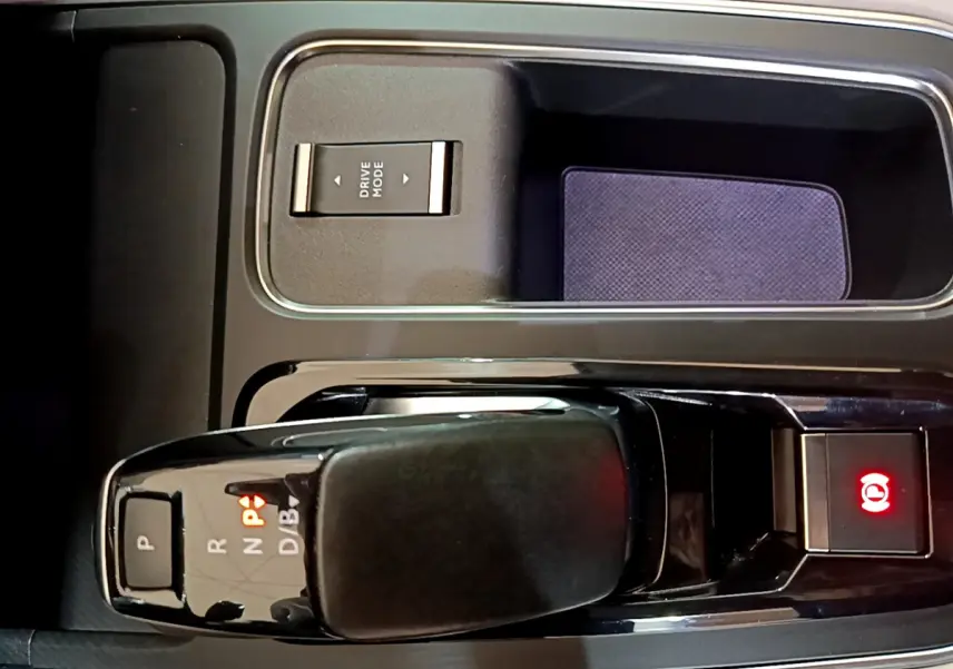 Gros plan sur la console centrale noire du Citroën C5 Aircross Hybrid 225 ë-EAT8 Shine avec levier de vitesses et bouton frein électrique allumé.