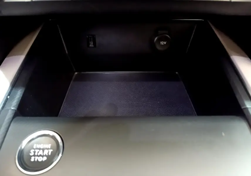 Détail du rangement central noir avec prise 12V et bouton démarrage sur le Citroën C5 Aircross Hybrid 225 ë-EAT8 Shine.