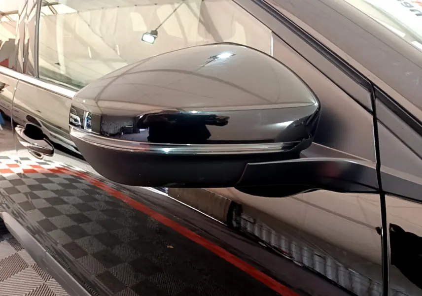 Rétroviseur droit noir brillant du Citroën C5 Aircross Hybrid 225 ë-EAT8 Shine, reflet sur carrosserie noire.