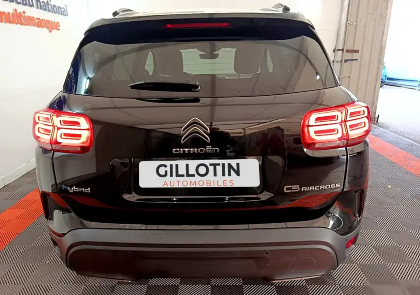 Vue arrière d'un Citroën C5 Aircross Hybrid noir avec feux arrière LED allumés et logo centré sur le hayon.