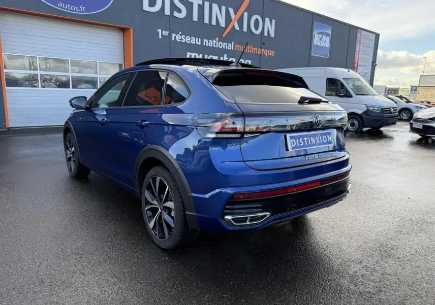 Volkswagen Taigo bleu récif métallisé vu 3/4 arrière droit avec jantes noires brillantes et toit ouvrant en verre