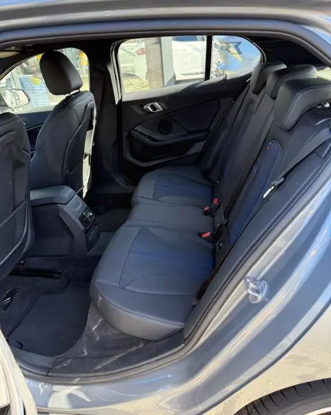 Vue intérieure côté droit de la banquette arrière en cuir gris foncé de la BMW Série 1 118d Edition Sport 2024.