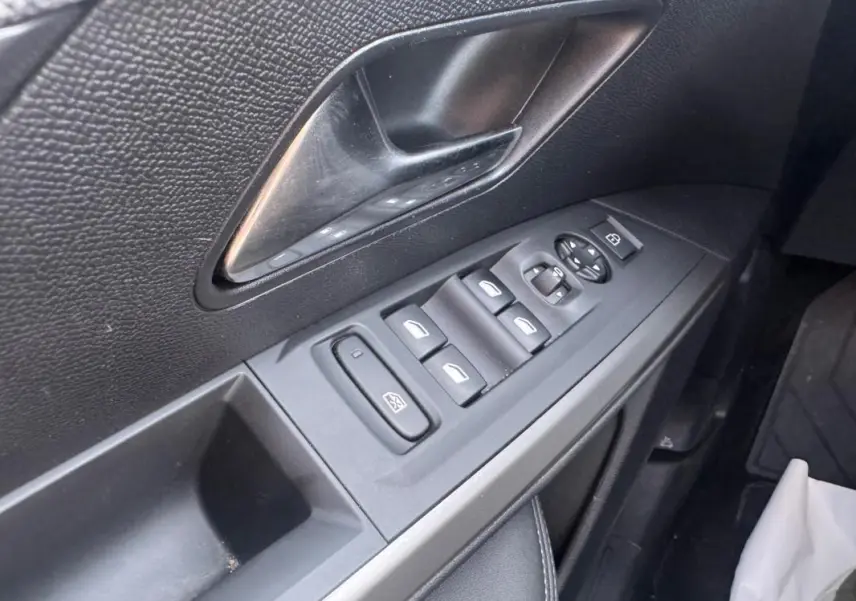 Gros plan sur la commande des vitres et rétroviseurs côté gauche intérieur noir du Peugeot 3008 Hybrid 145 Allure 2025.