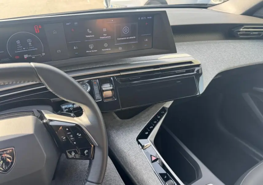 Vue intérieure côté conducteur du tableau de bord et console centrale du Peugeot 3008 Hybrid 145 Allure 2025 noir.