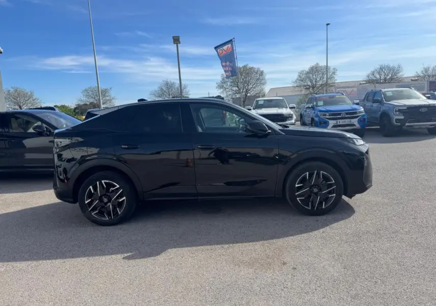 Profil côté gauche du Peugeot 3008 Hybrid noir 2025 avec jantes alliage 19 pouces, stationné en extérieur sous ciel bleu.