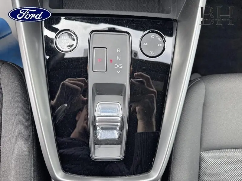 Console centrale noire brillante avec sélecteur de vitesses électronique et bouton start/stop, intérieur tissu gris.