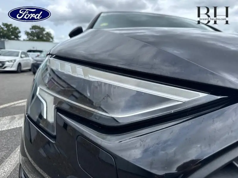 Gros plan sur le phare avant gauche noir Mythic métallisé de l'Audi A3 Sportback 35 TDI 2022 avec détails LED distinctifs.