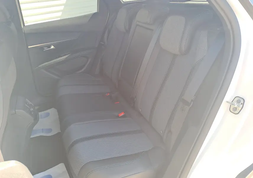 Vue côté droit de la banquette arrière noire et tissu gris du Peugeot 3008 2023 blanc nacré avec porte ouverte.