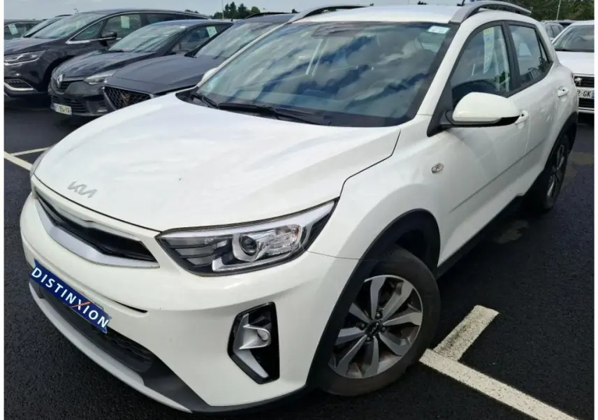 Vue 3/4 avant droite d’un KIA Stonic blanc 2023 avec détails noirs sur les passages de roues et calandre.