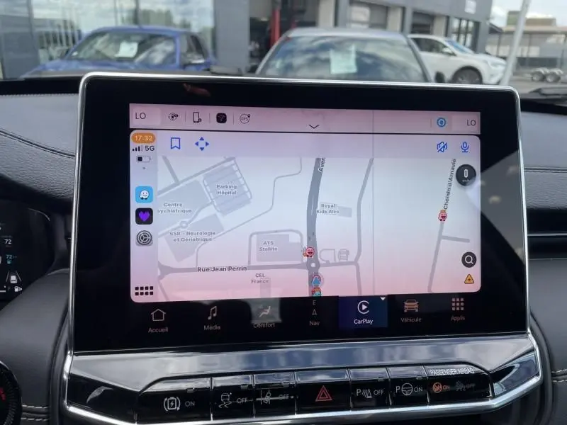 Écran tactile central du Jeep Compass 2023 affichant la navigation avec interface CarPlay, intérieur noir moderne.