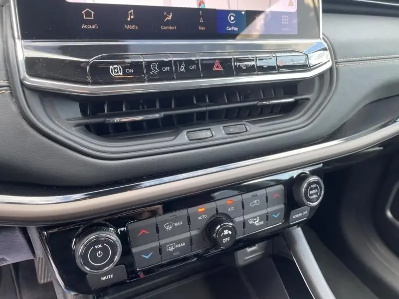 Détail du tableau de bord du Jeep Compass gris 2023, montrant les commandes climatisation et écran tactile central.