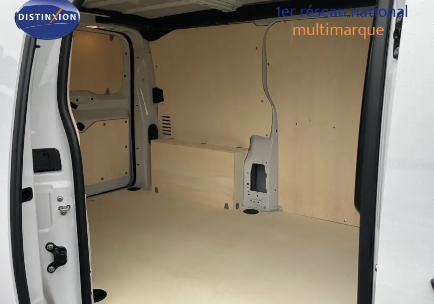 Vue intérieure de la zone de chargement du Peugeot Expert Fourgon blanc, avec habillage bois clair sur les parois et le sol.