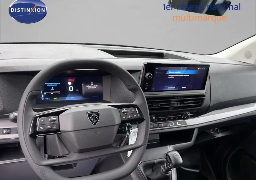 Vue intérieure centrée sur le volant et le tableau de bord du Peugeot Expert Fourgon blanc, avec écran tactile et levier de vitesse manuel.