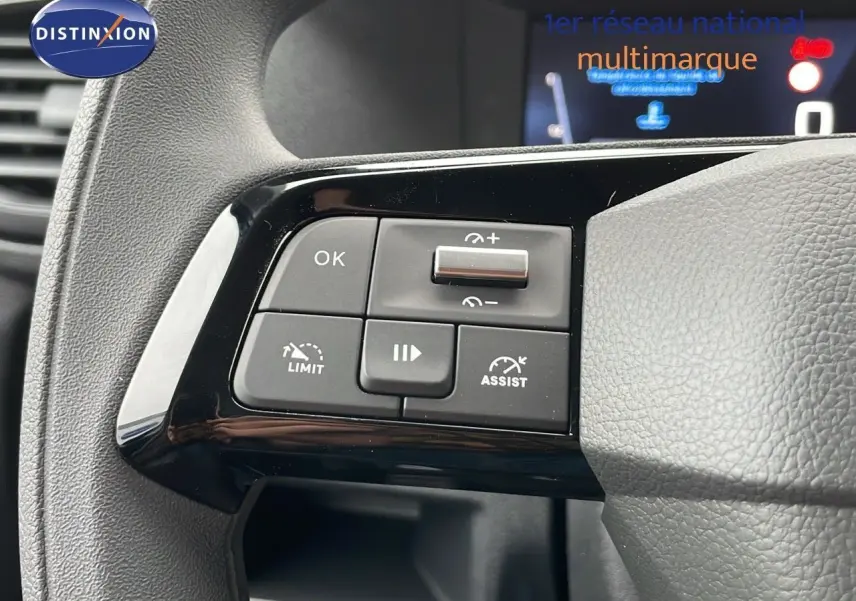 Gros plan sur les commandes au volant noir du Peugeot Expert Fourgon blanc, version 2025, montrant les boutons de régulateur et limiteur de vitesse.