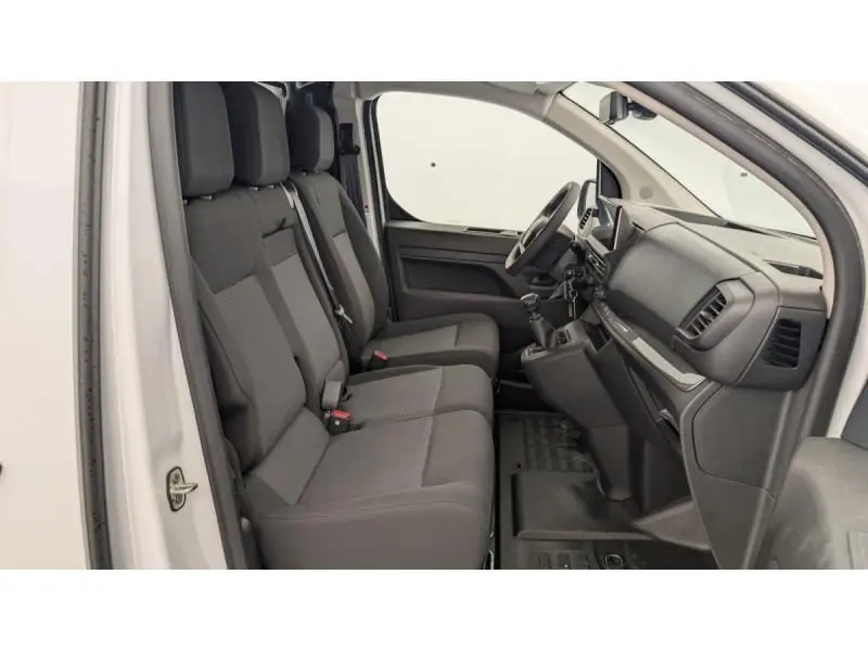 Vue intérieure côté conducteur du Peugeot Expert Fourgon blanc 2025, montrant les sièges et le tableau de bord noir.