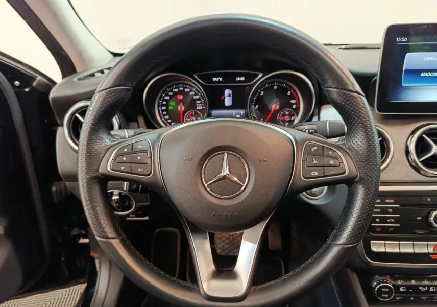 Vue rapprochée du volant cuir noir multifonctions d'une Mercedes GLA 220 d Business Exec 2018 avec tableau de bord numérique.