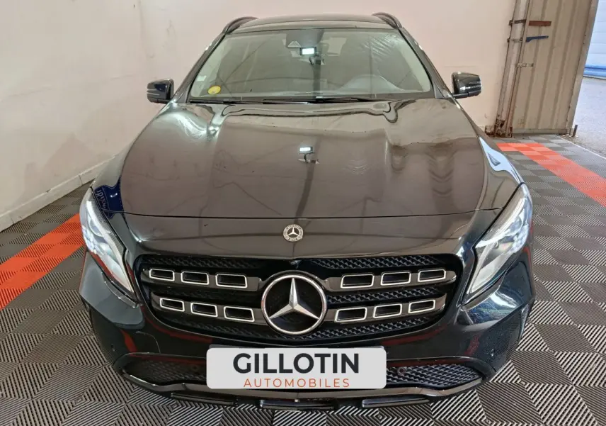 Vue frontale d'un Mercedes GLA 220 d noir brillant avec calandre distinctive et phares LED allumés.