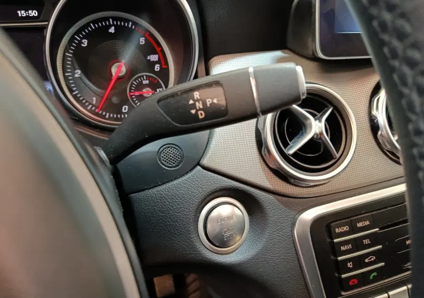Détail intérieur du tableau de bord noir du Mercedes GLA 220 d 2018 avec bouton démarrage et commandes de boîte automatique.