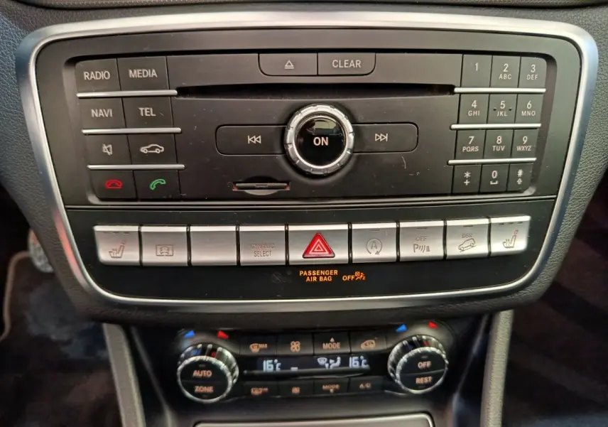 Vue rapprochée du tableau de bord noir du Mercedes GLA 220 d avec commandes multimédia et climatisation digitale.