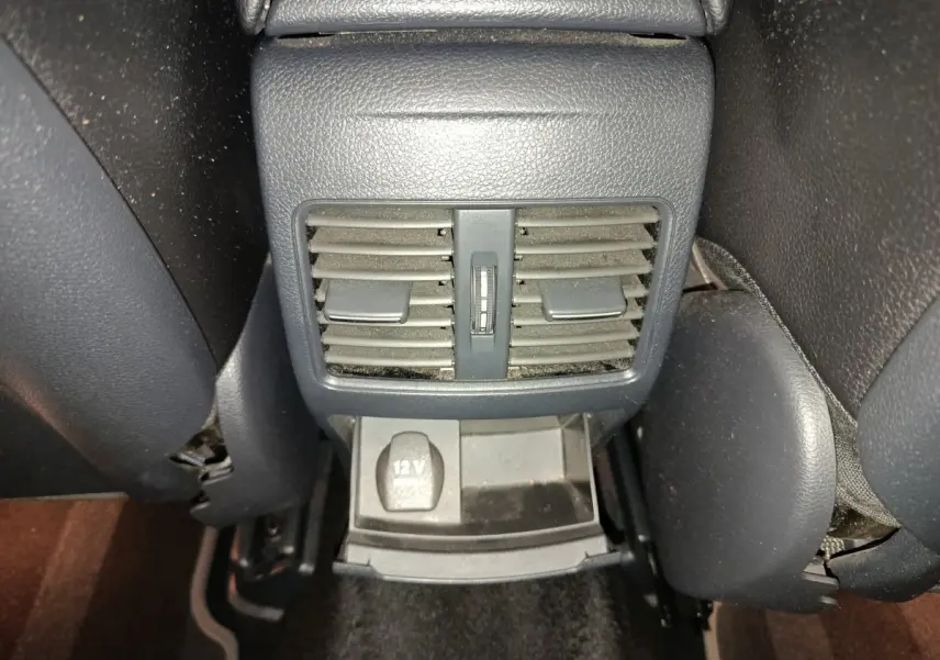 Vue rapprochée des aérateurs arrière noirs et prise 12V du Mercedes GLA 220 d Business Exec 2018.