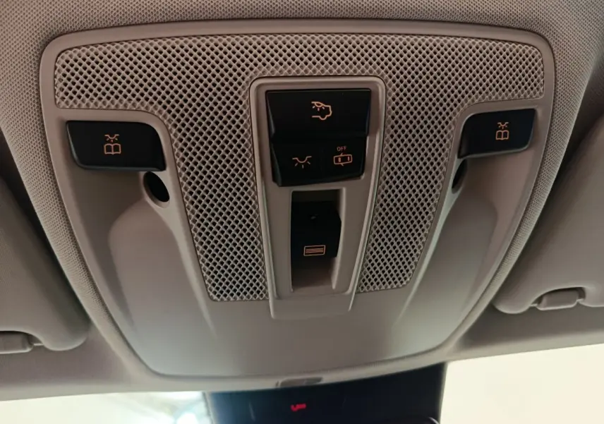 Vue en gros plan du panneau de commandes plafonnier gris clair du Mercedes GLA noir, avec boutons d'éclairage et ouverture toit ouvrant.