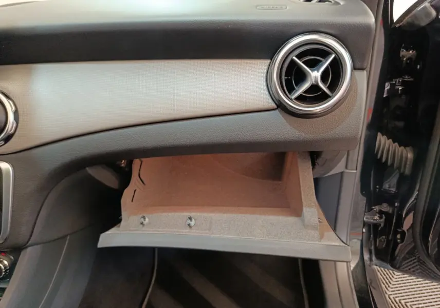 Intérieur du Mercedes GLA 220 d 2018 en noir, vue côté passager avec boîte à gants ouverte et aérateur rond chrome.
