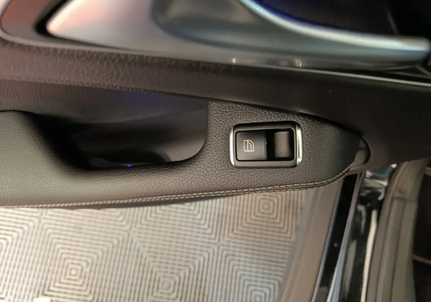 Bouton de commande de lève-vitre sur la porte côté conducteur d'un Mercedes GLA 220 d noir, vue rapprochée intérieure.