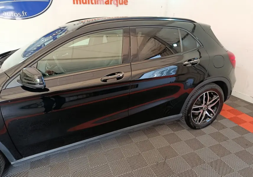 Profil côté gauche d'une Mercedes GLA 220 d noire, soulignant ses jantes alliage et rétroviseurs chromés.