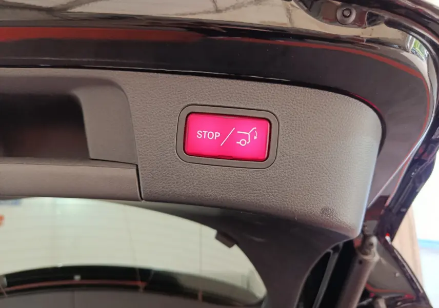 Bouton rouge stop ouverture coffre électrique sur hayon intérieur d’un Mercedes GLA noir 2018
