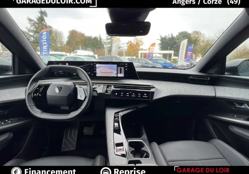 Vue intérieure avant du Peugeot 5008 2024 hybride, tableau de bord moderne avec écran tactile et volant compact noir.