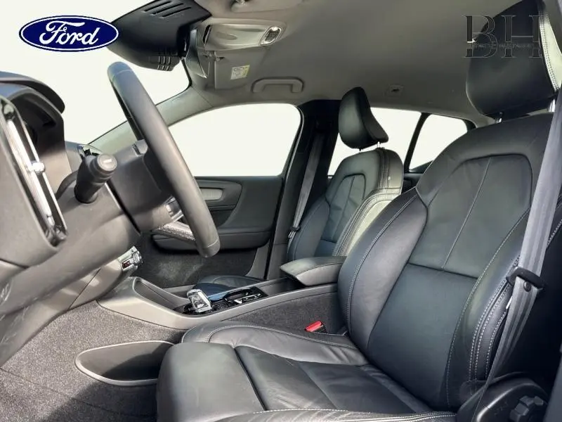 Intérieur avant en cuir noir, vue côté gauche sur les sièges et le volant, ambiance sobre et moderne.