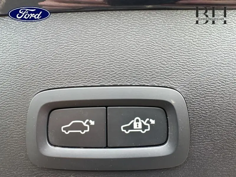 Boutons de commande d'ouverture et de verrouillage du coffre sur tableau de bord noir, sans vue du véhicule.