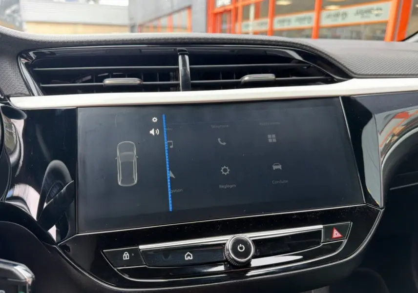 Vue rapprochée de l’écran tactile central noir brillant de l’Opel Corsa Hybrid 2026, avec commandes visibles.