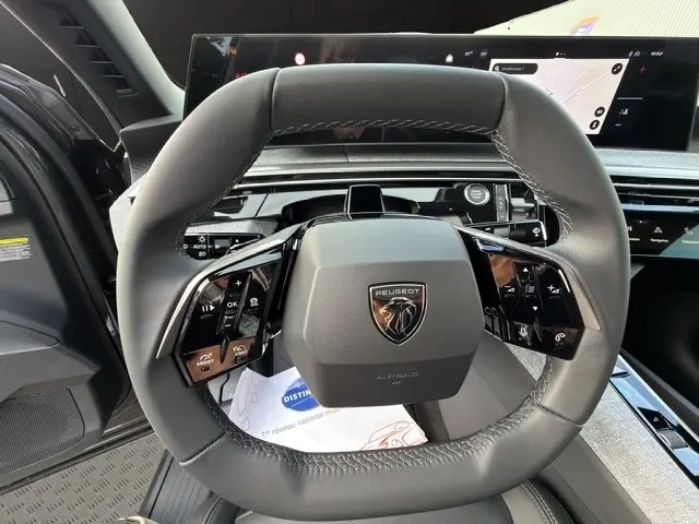 Gros plan sur le volant cuir noir du Peugeot 3008 2026 avec commandes multifonctions et tableau de bord digital.