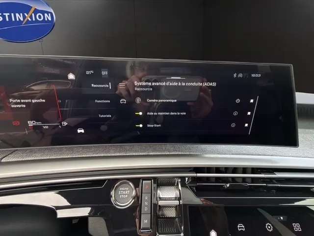 Vue rapprochée de l’écran tactile central et du bouton démarrage du tableau de bord du Peugeot 3008 gris foncé.
