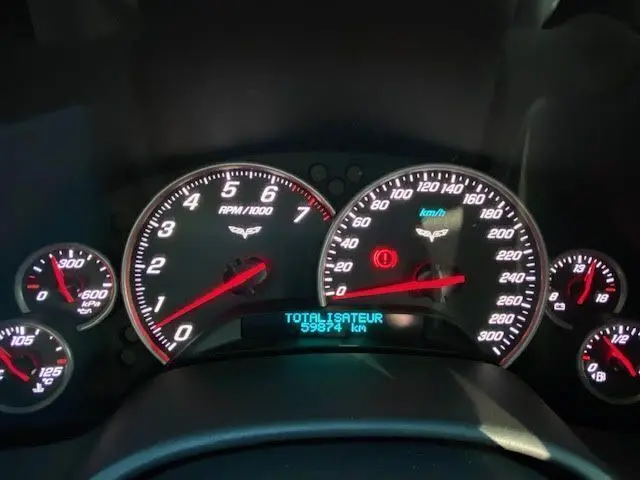 Gros plan sur le tableau de bord noir de la Chevrolet Corvette C6 Targa 2005, affichant compte-tours et compteur kilométrique.