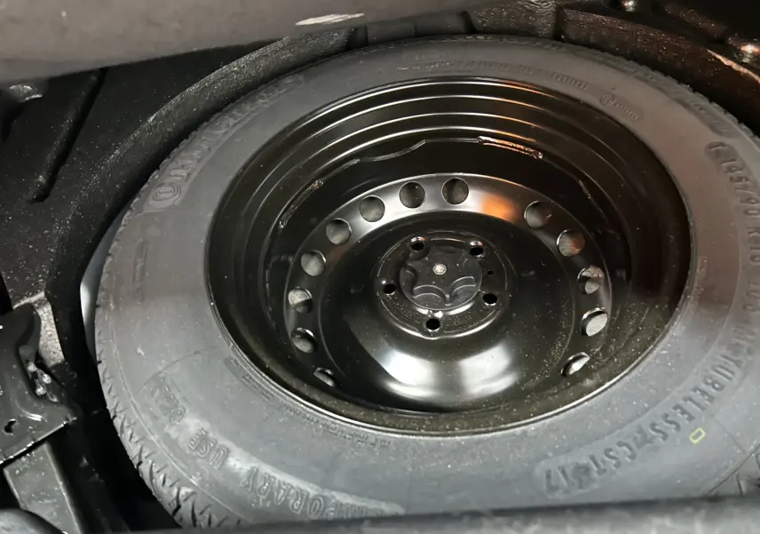 Gros plan sur la roue de secours noire en acier du Renault Kadjar gris, visible dans le coffre du SUV.