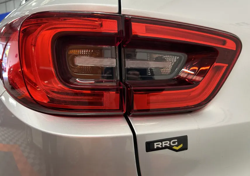 Gros plan sur le feu arrière droit rouge d’un Renault Kadjar gris 2015 avec badge RRG sur la malle arrière.