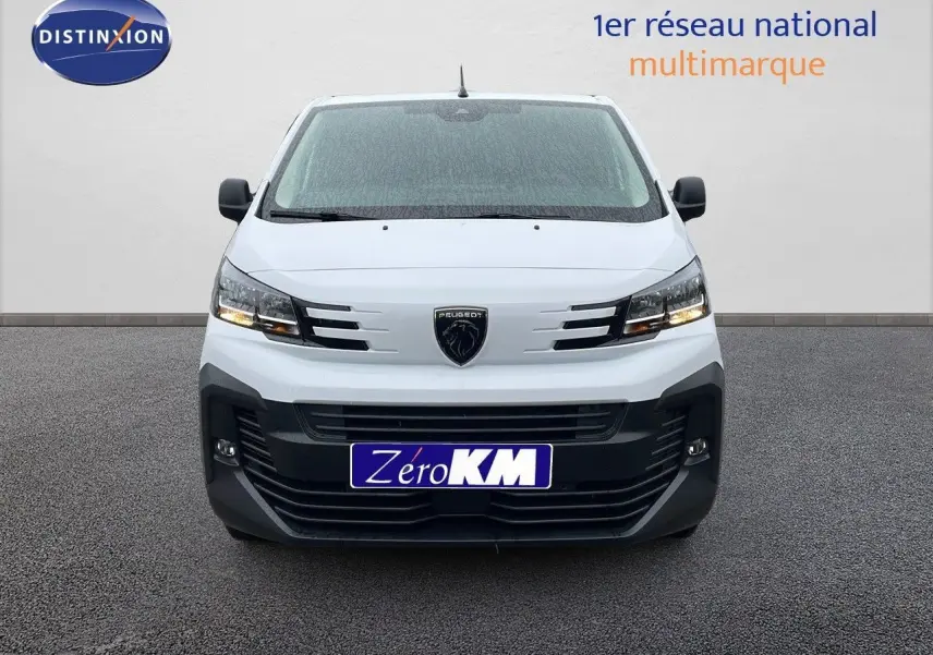 Vue avant du Peugeot Expert Fourgon blanc 2025 avec calandre noire et phares allumés sur fond neutre.